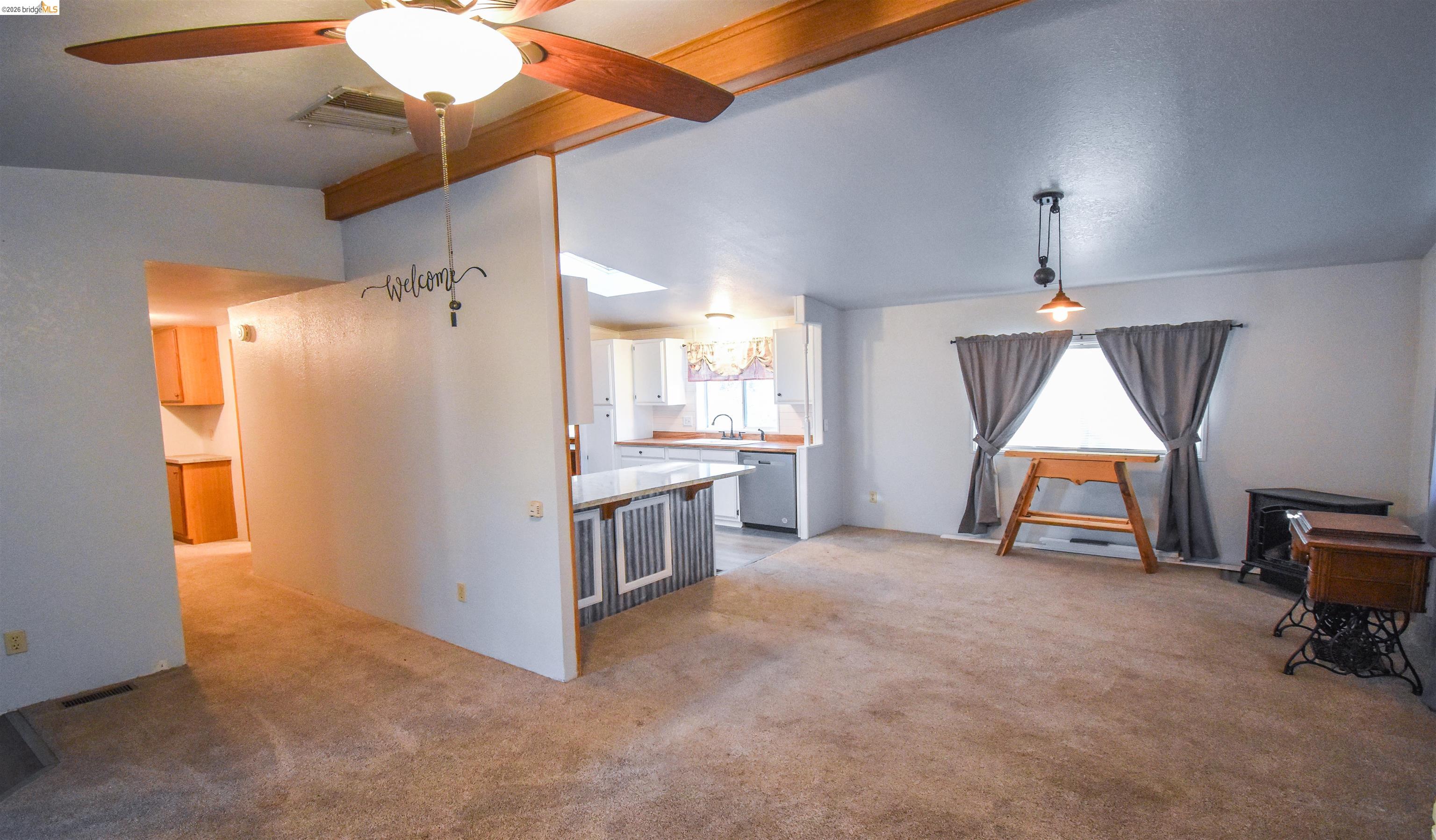 18330 Wards Ferry, Unit 32 Sonora, CA 95370 - Photo 29 of 36 Living area featuring a ceiling fan, light colored carpet, and beam ceiling