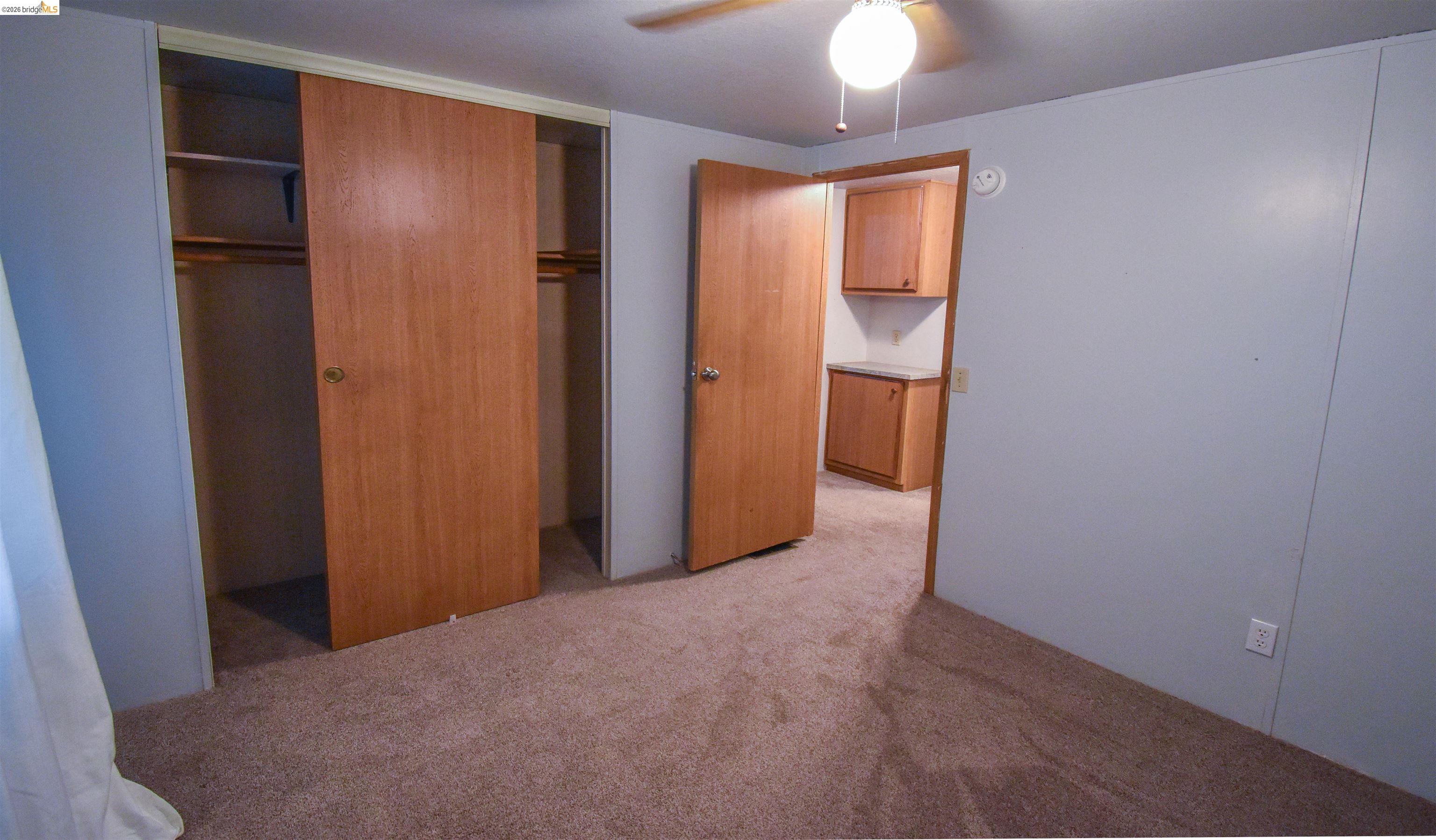 18330 Wards Ferry, Unit 32 Sonora, CA 95370 - Photo 31 of 36 Unfurnished bedroom with light carpet, a closet, and a ceiling fan