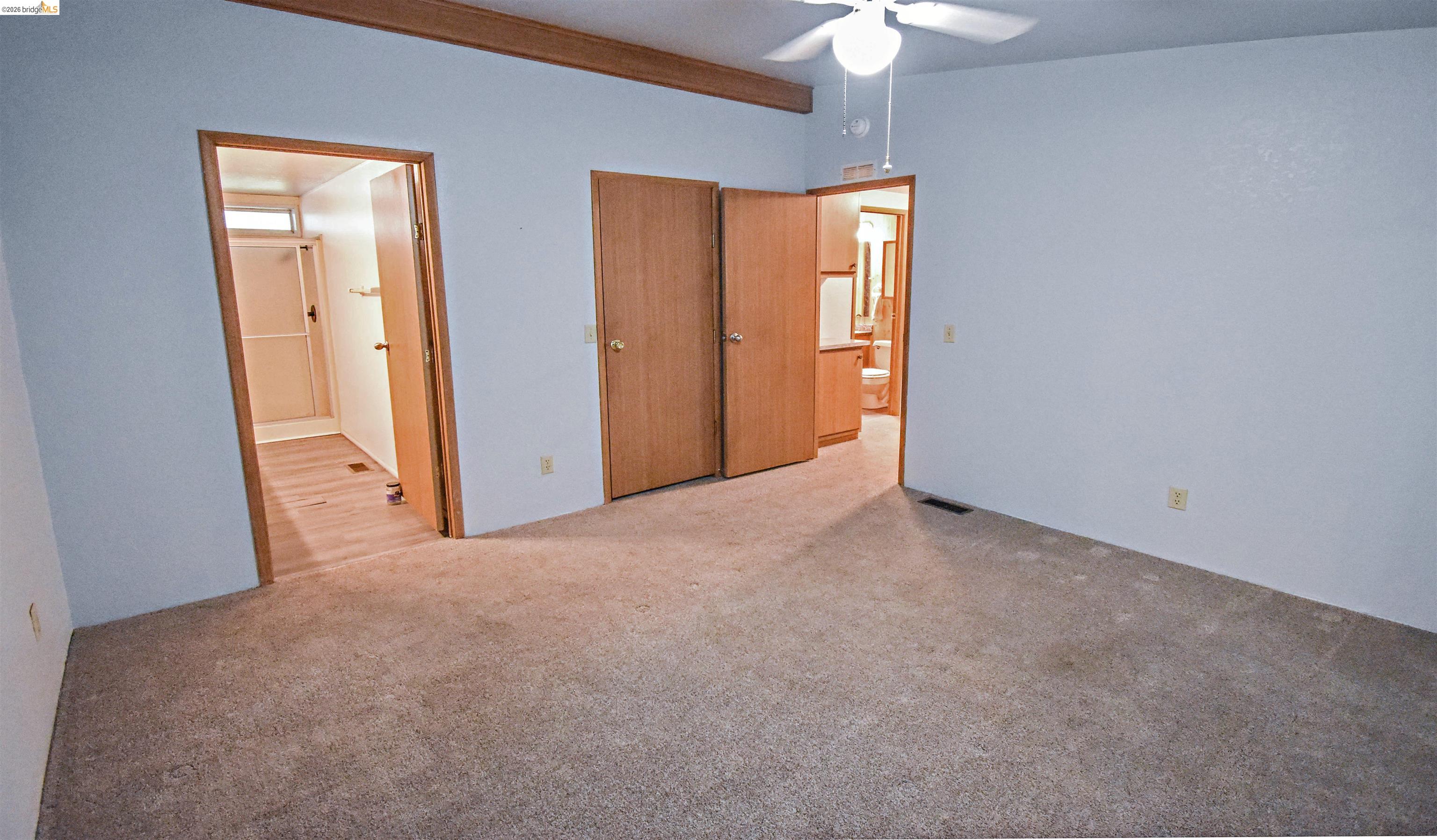 18330 Wards Ferry, Unit 32 Sonora, CA 95370 - Photo 34 of 36 Unfurnished bedroom featuring ensuite bath, carpet floors, a closet, and a ceiling fan