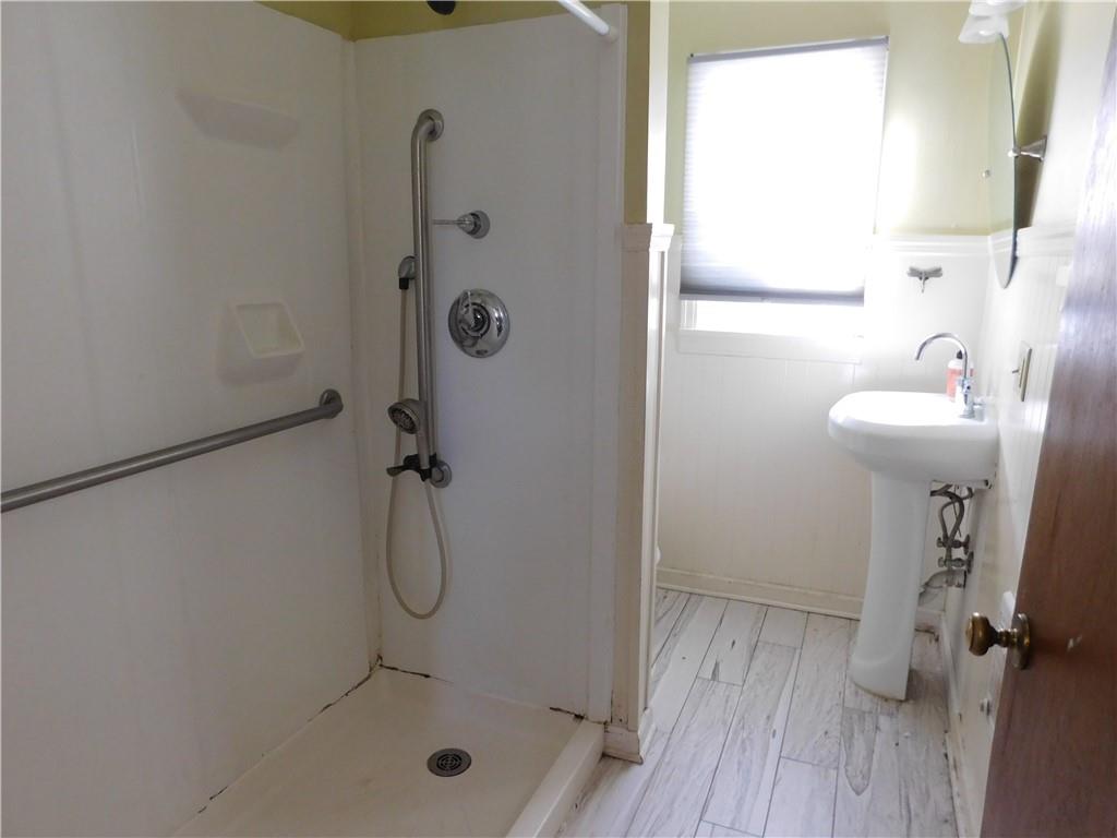 119 April Way Braddock, PA 15104 - Photo 11 of 16 a bathroom with a sink a glass door shower and a mirror