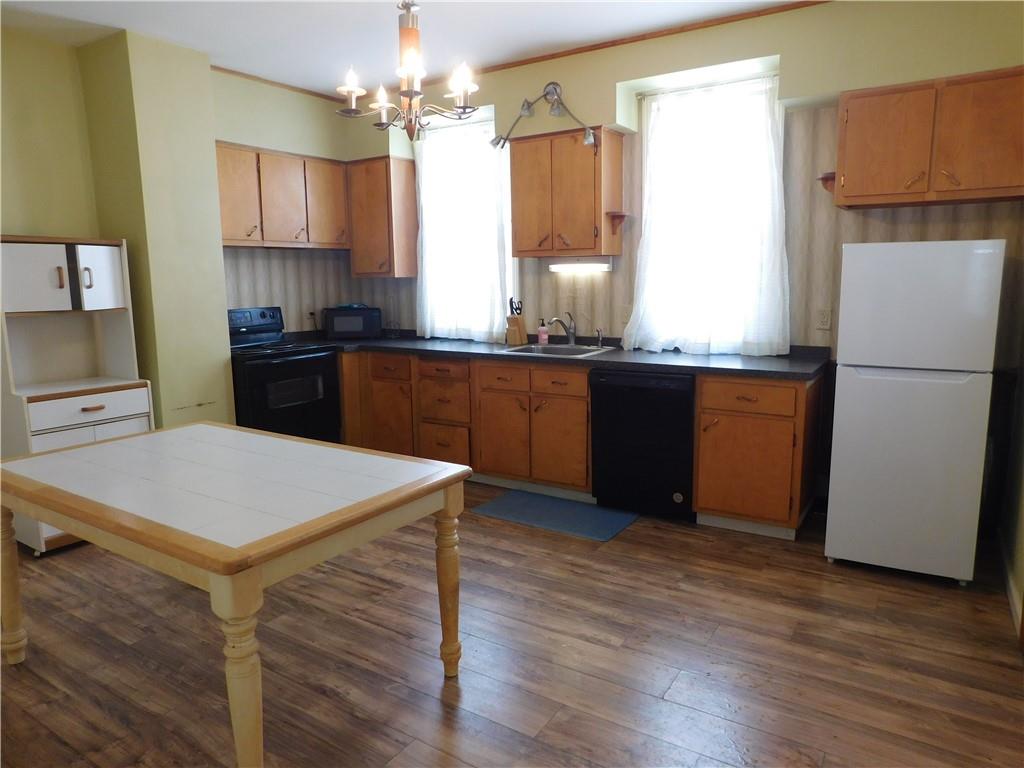 119 April Way Braddock, PA 15104 - Photo 4 of 16 a kitchen with a refrigerator a sink wooden floor and cabinets