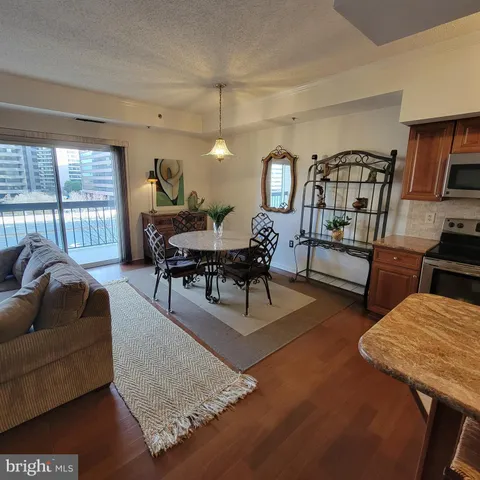 a living room with patio furniture and a wooden floor