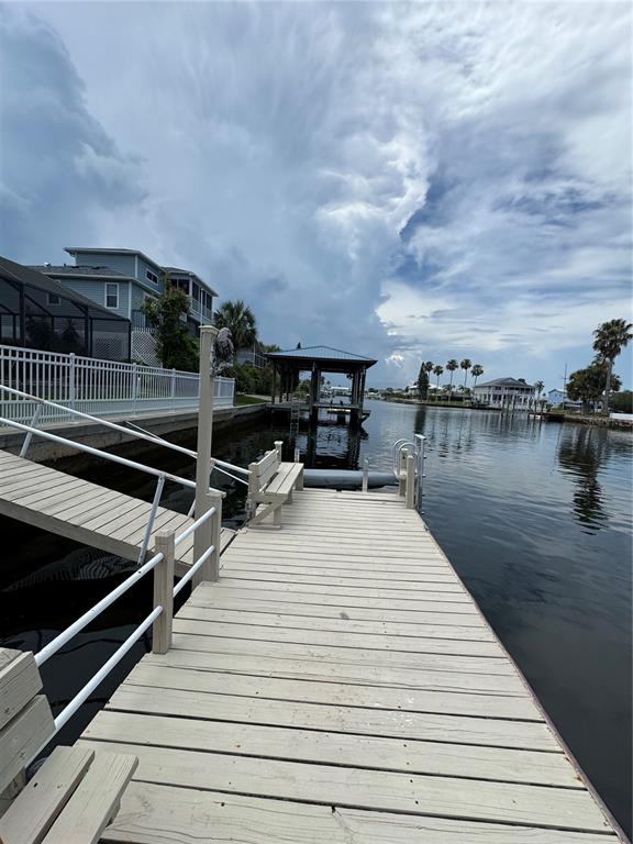 4385 7th Isle Drive Hernando Beach, FL 34607 - Photo 18 of 25 a view of roof deck with two chairs and wooden floor