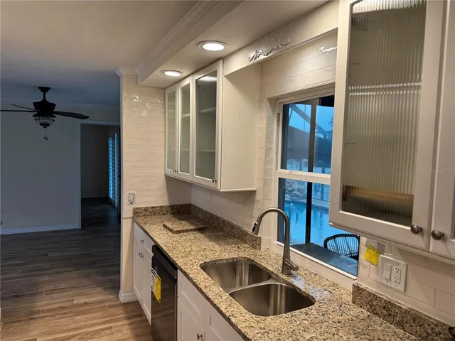 a kitchen with stainless steel appliances granite countertop a sink and a refrigerator