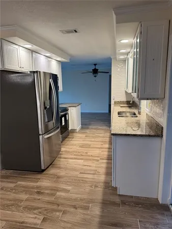a kitchen with stainless steel appliances granite countertop a refrigerator and a sink
