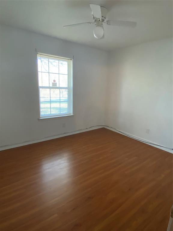 136 Richard Lane Azle, TX 76020 - Photo 9 of 13 an empty room with wooden floor fan and windows