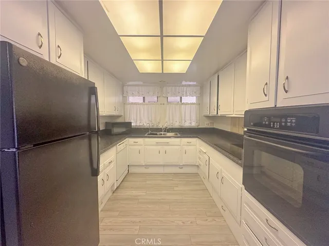 a kitchen with a refrigerator a sink and cabinets