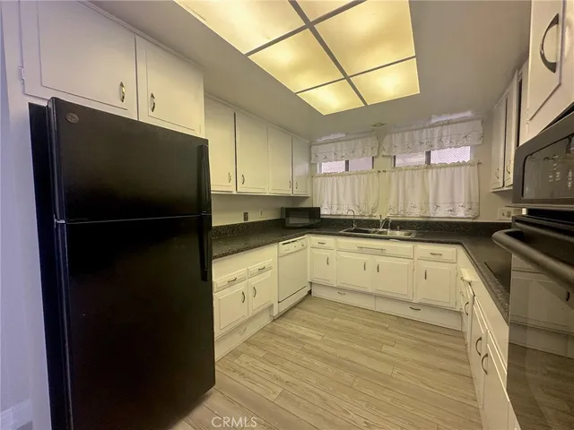 a kitchen with granite countertop wooden cabinets and white appliances