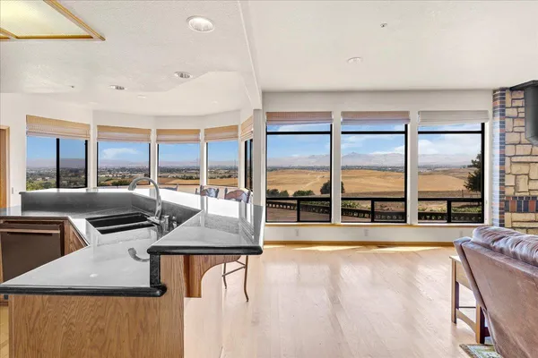 a bathroom with a granite countertop sink mirror bathtub and next to a window