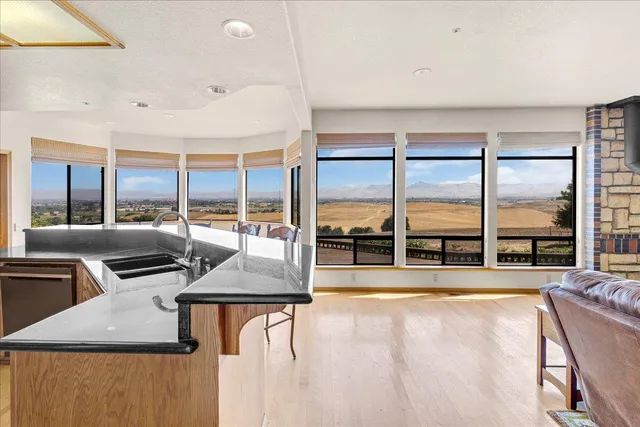 a bathroom with a granite countertop sink mirror bathtub and next to a window