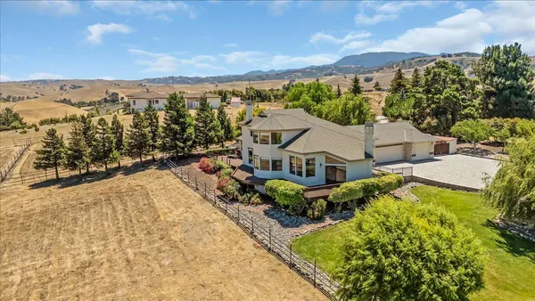 an aerial view of residential houses with outdoor space and trees