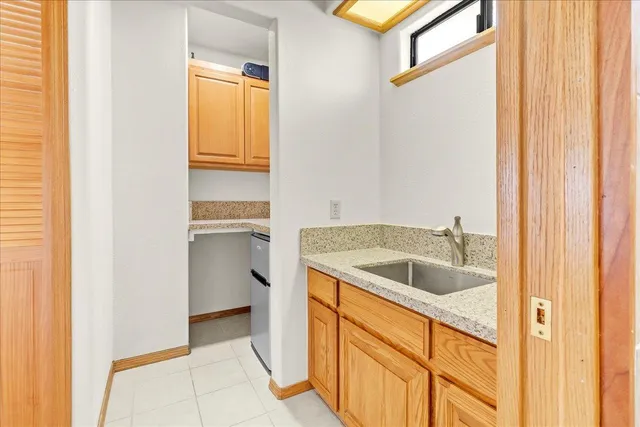 a view of a chairs and fire pit in the patio next to a yard