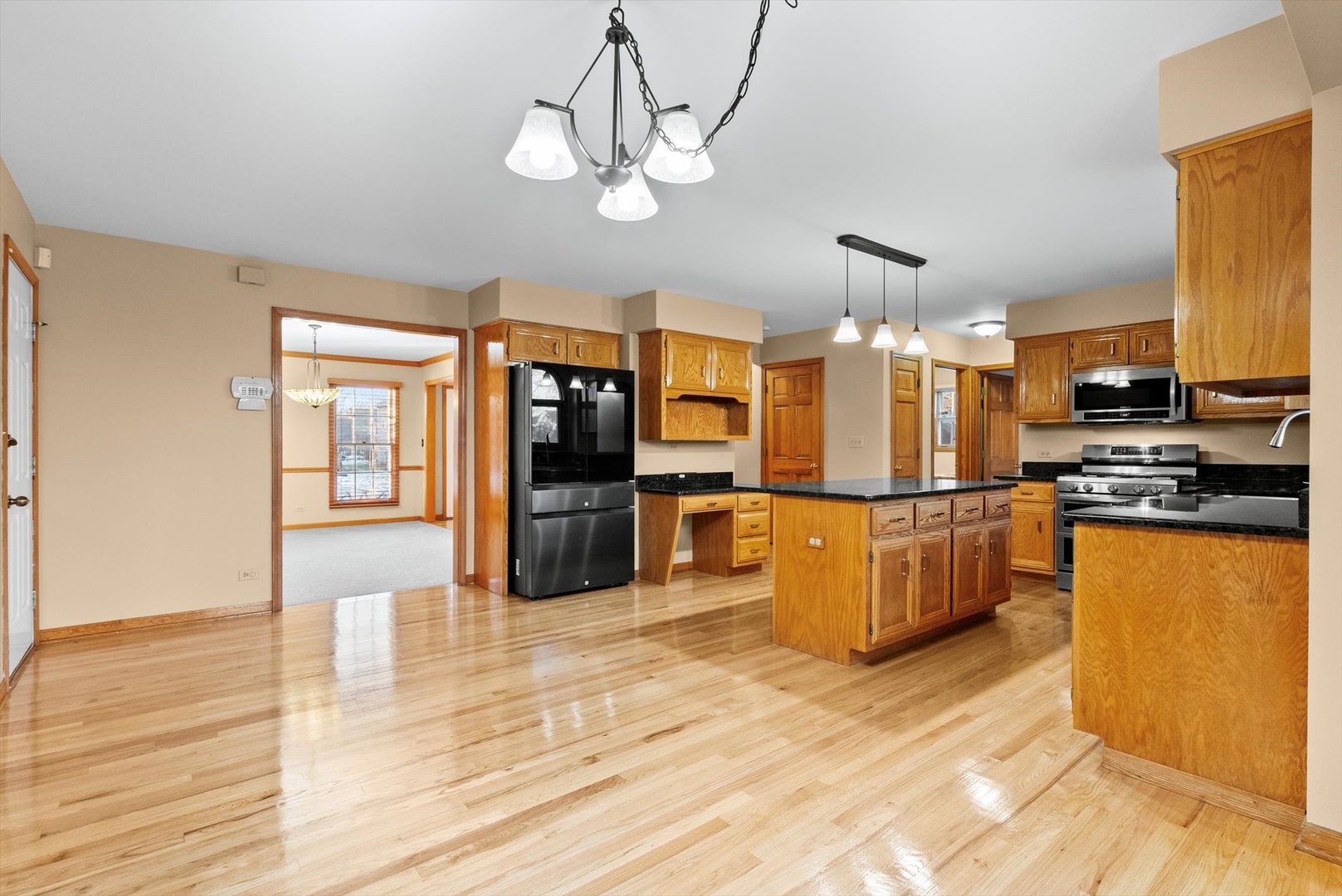 1107 Conan Doyle Road Naperville, IL 60564 - Photo 7 of 34 a kitchen with stainless steel appliances kitchen island granite countertop a refrigerator a stove top oven a sink dishwasher and wooden floor