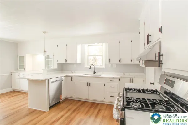 a kitchen with granite countertop a sink stove and cabinets