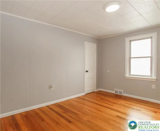a view of empty room with wooden floor