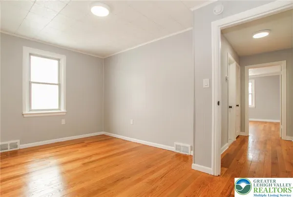 a view of a room with wooden floor and a window