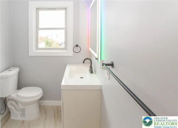 a bathroom with a sink toilet and window