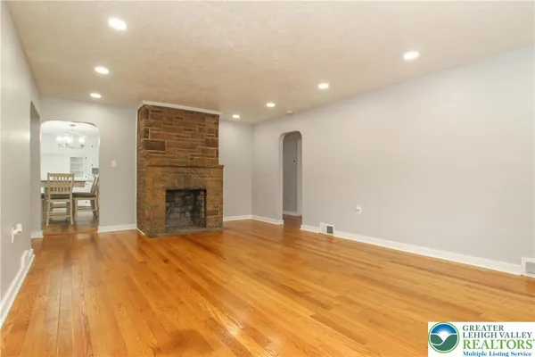 a view of empty room with wooden floor and fireplace
