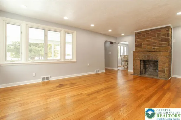 a view of an empty room with a window and fireplace