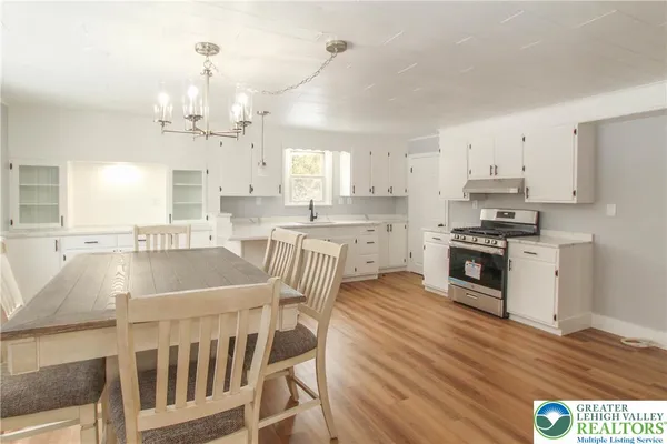 a kitchen with stainless steel appliances granite countertop a stove a sink dishwasher and a refrigerator with wooden floor