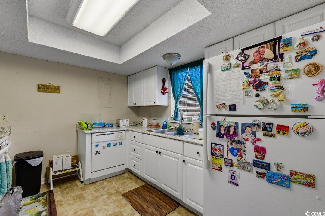 6616 Wintergreen Point Myrtle Beach, SC 29588 - Photo 8 of 29 Kitchen with white appliances, white cabinets, light countertops, a textured ceiling, and electric panel