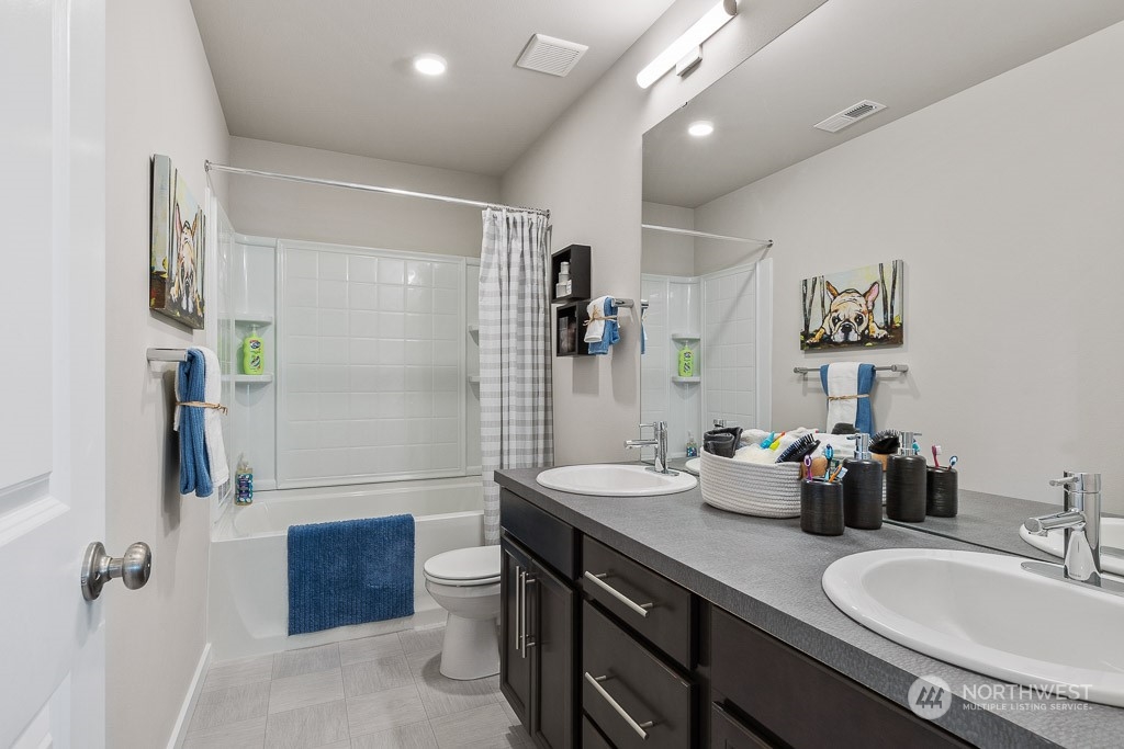 126 177th Street Southeast Bothell, WA 98012 - Photo 28 of 30 a bathroom with double vanity sinks a toilet a mirror and shower