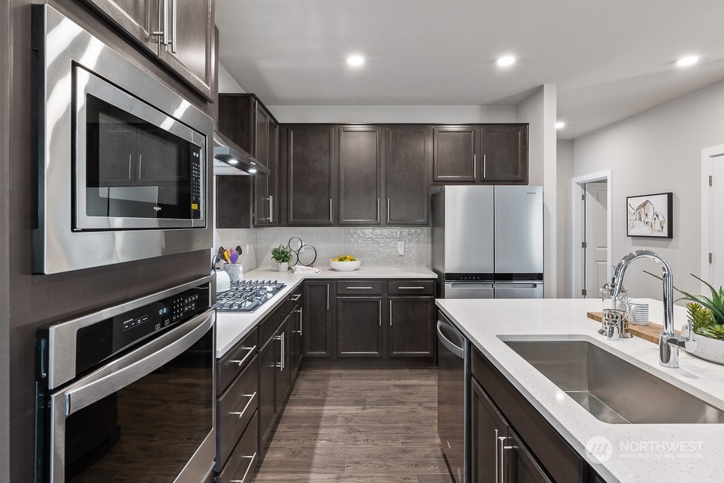 126 177th Street Southeast Bothell, WA 98012 - Photo 8 of 30 a kitchen with stainless steel appliances granite countertop a sink and stove top oven