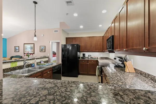 a kitchen with stainless steel appliances granite countertop a sink stove and cabinets