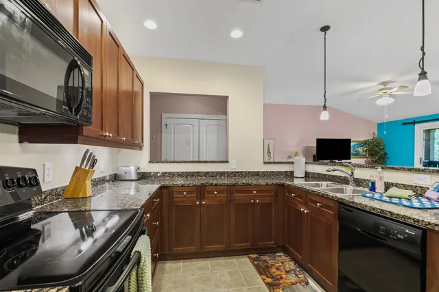 a kitchen with stainless steel appliances granite countertop a sink refrigerator and cabinets