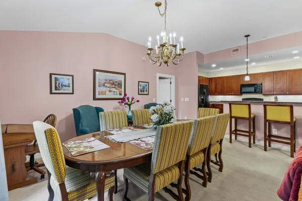 a view of a dining room with furniture a chandelier and window