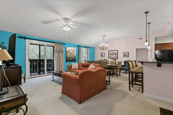 a living room with furniture a ceiling fan and a flat screen tv