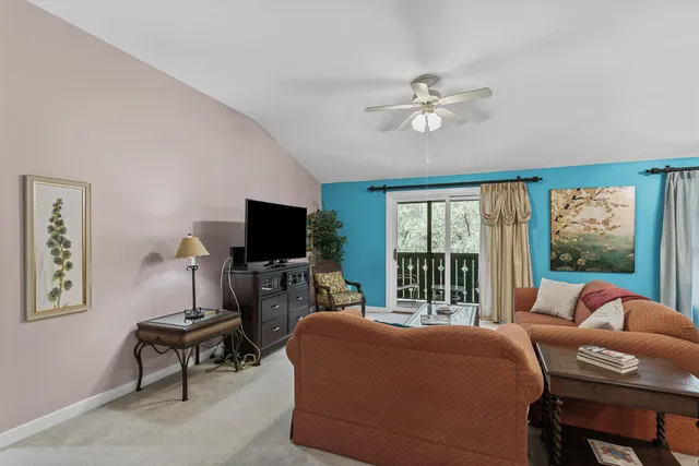 a living room with furniture a flat screen tv and a window