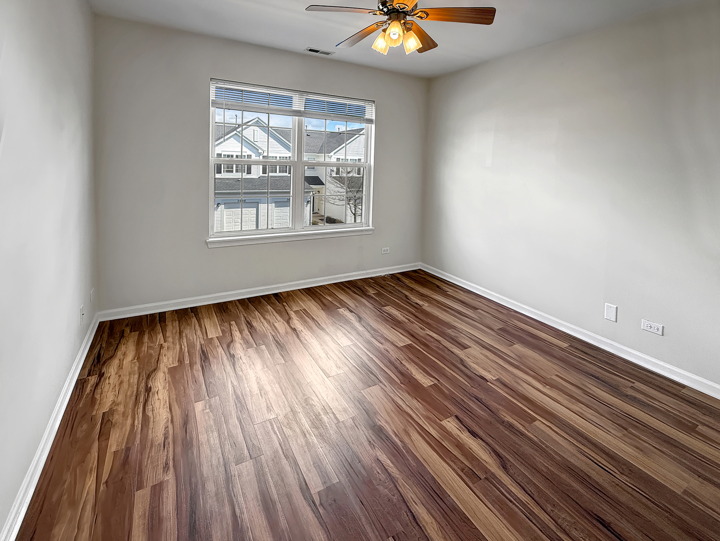 3078 Falling Waters Lane, Unit 3078 Lindenhurst, IL 60046 - Photo 15 of 19 an empty room with wooden floor windows and a chandelier fan