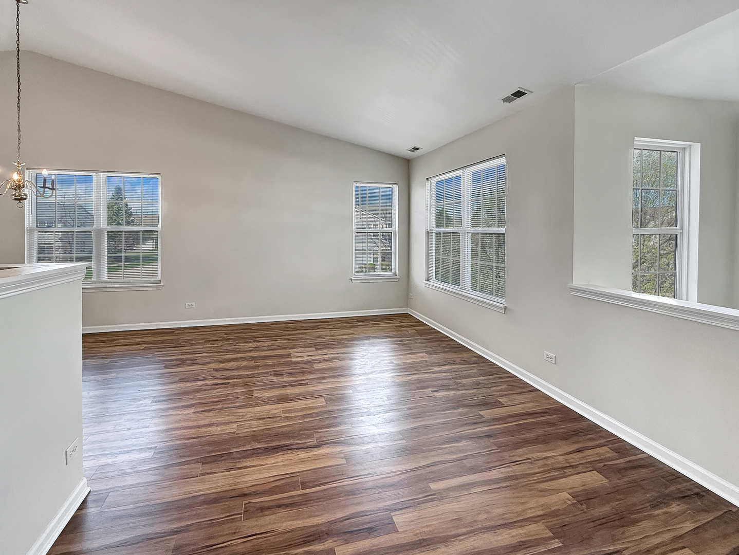 3078 Falling Waters Lane, Unit 3078 Lindenhurst, IL 60046 - Photo 5 of 19 a view of an empty room with wooden floor and a window