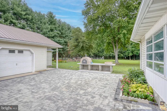 a view of a house with a yard and potted plants