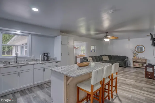 a kitchen with stainless steel appliances granite countertop a stove a sink a dining table and chairs