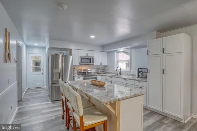 a kitchen with refrigerator and chairs