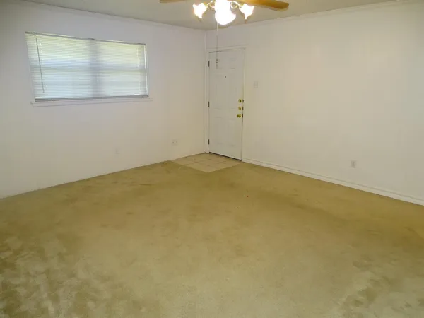 an empty room with a chandelier fan