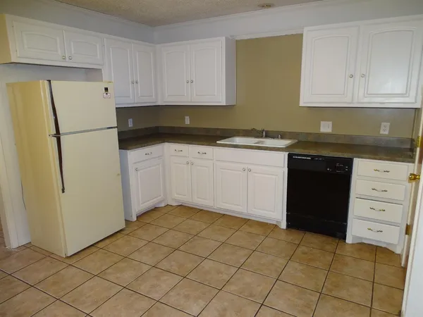 a kitchen with a stove top oven and cabinets