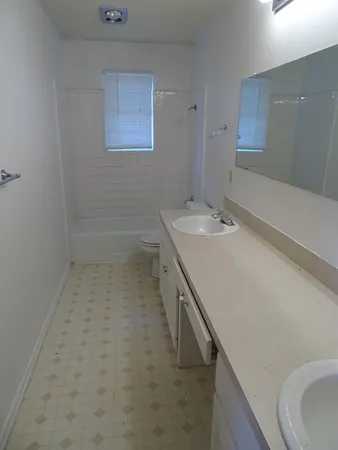 a bathroom with a sink a tub and a mirror
