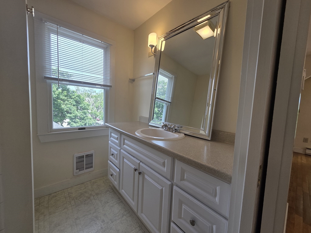 14 Hawkes Street, Unit 2 Marblehead, MA 01945 - Photo 6 of 12 a bathroom with a double vanity sink and a mirror