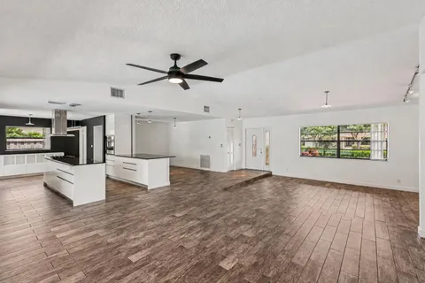 a kitchen with granite countertop a sink and white cabinets