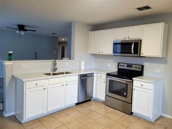 a kitchen with white cabinets stainless steel appliances and sink