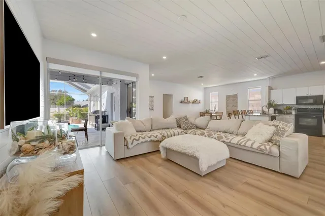 a kitchen with stainless steel appliances granite countertop a table chairs and a refrigerator