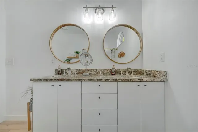 a bedroom with a bed a large window and potted plant on the dresser