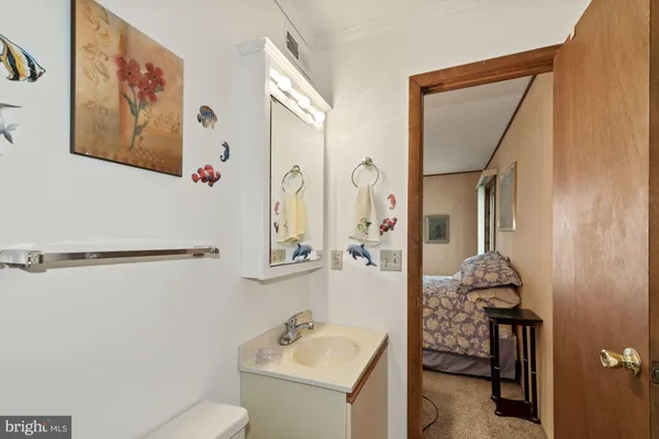 a bathroom with a sink and mirror with toilet