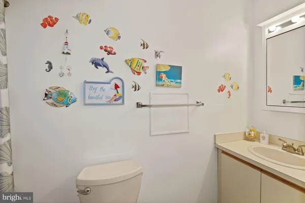 a white bathroom with a sink a toilet and a shower curtain
