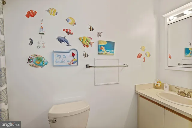 a white bathroom with a sink a toilet and a shower curtain