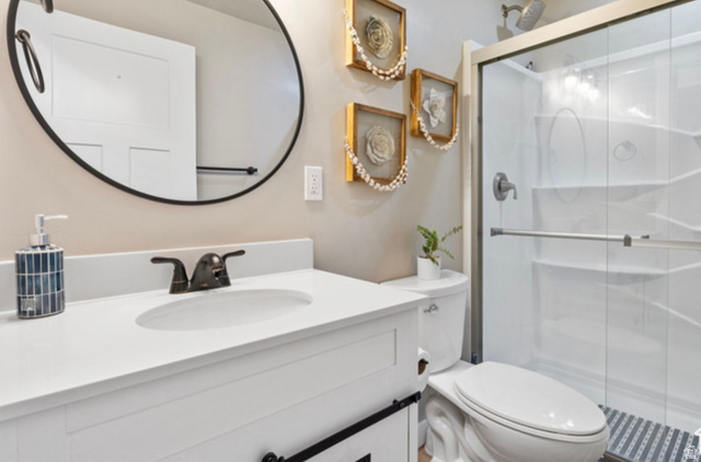 1295 East Granite Peak Road Eagle Mountain, UT 84005 - Photo 23 of 35 Bathroom featuring a white vanity with an integrated sink, dark bronze-finish faucet, and a round black-framed mirror