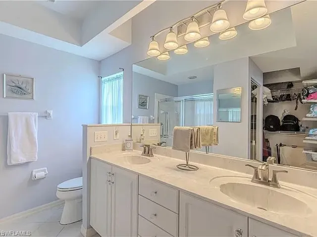 a bathroom with a double vanity sink mirror and toilet